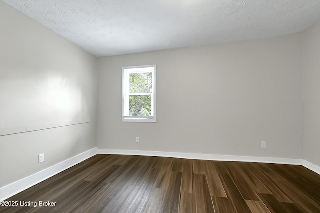 unfurnished room with dark wood-style flooring, a textured ceiling, and baseboards