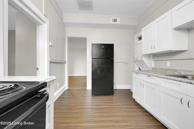 kitchen featuring white cabinetry, visible vents, black appliances, and wood finished floors