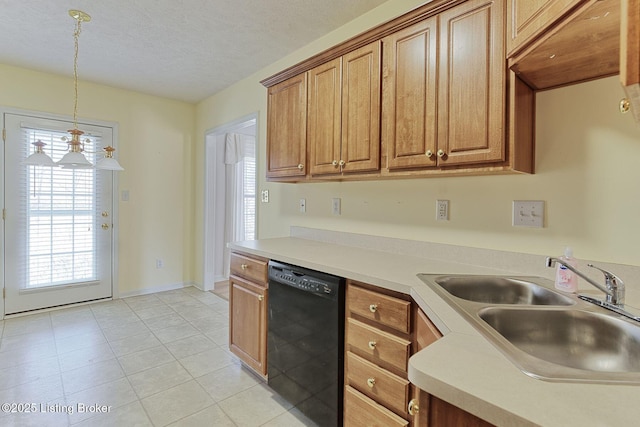 kitchen featuring brown cabinets, decorative light fixtures, a sink, a textured ceiling, and dishwasher