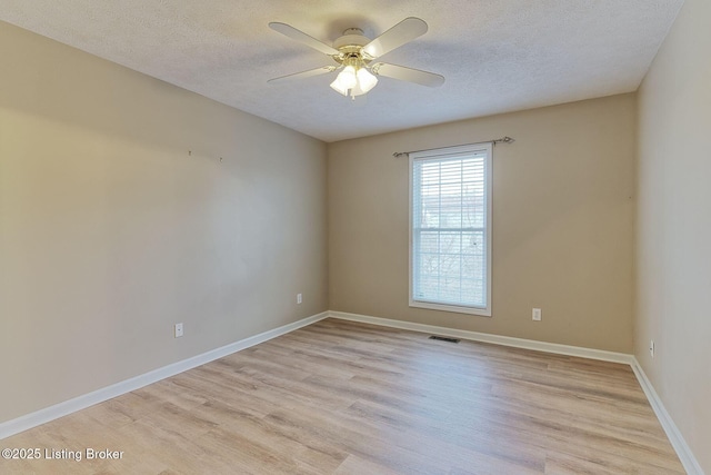 unfurnished room featuring light wood finished floors, visible vents, baseboards, a ceiling fan, and a textured ceiling