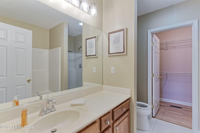 full bath with visible vents, a shower, toilet, tile patterned floors, and vanity