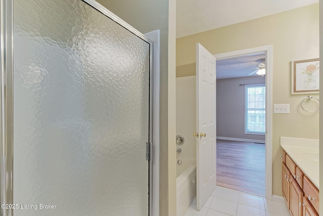 bathroom featuring a textured ceiling, tile patterned flooring, a bathing tub, a shower with shower door, and vanity