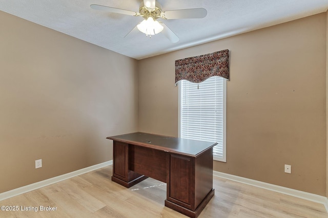 unfurnished office with a ceiling fan, light wood-style flooring, and baseboards