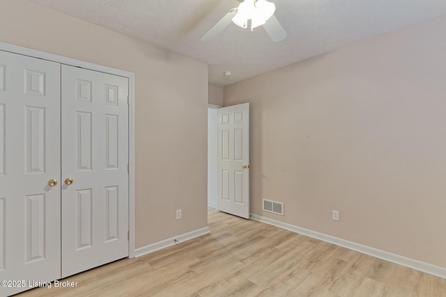 unfurnished bedroom with ceiling fan, visible vents, baseboards, a closet, and light wood finished floors