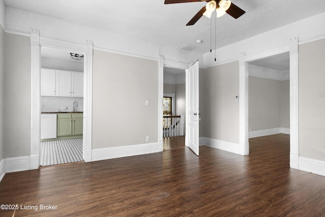 unfurnished room featuring a sink, ceiling fan, wood finished floors, and baseboards