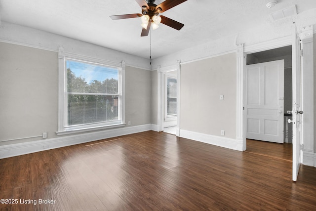 spare room featuring ceiling fan, baseboards, and wood finished floors