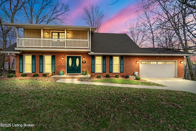 view of front of property with a balcony, an attached garage, concrete driveway, a lawn, and brick siding