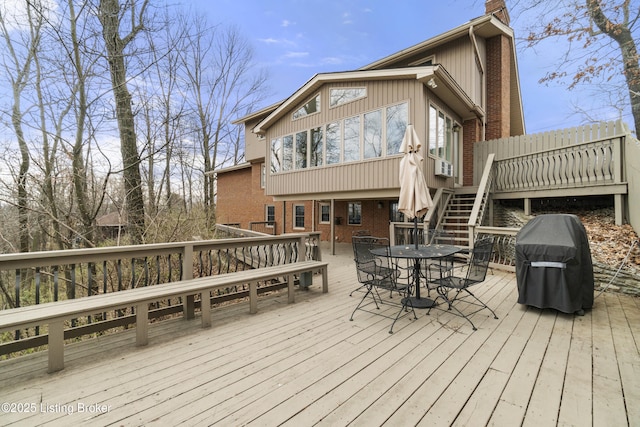 deck with area for grilling, cooling unit, stairway, and outdoor dining area