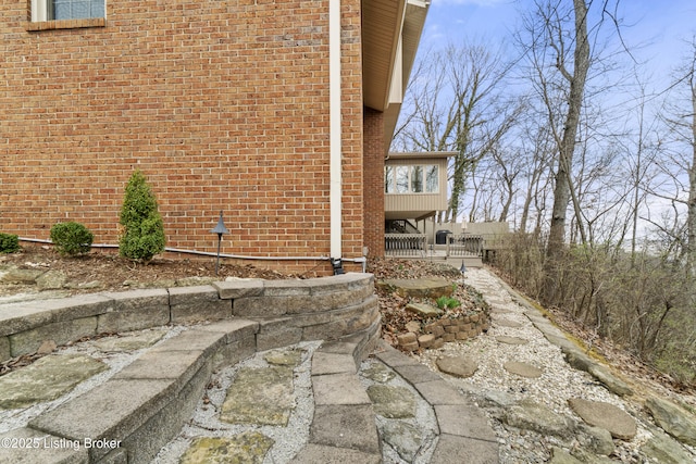 view of home's exterior with brick siding and fence