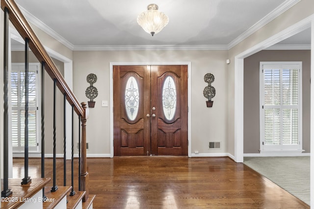 entrance foyer with visible vents, crown molding, baseboards, stairs, and wood finished floors