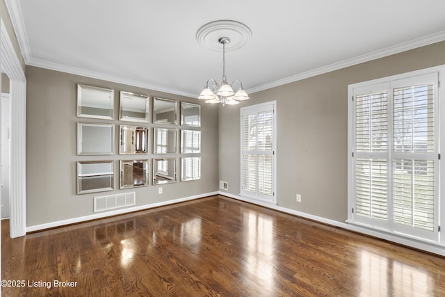 empty room featuring wood finished floors, visible vents, baseboards, an inviting chandelier, and crown molding