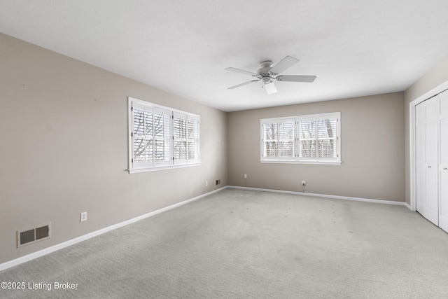 unfurnished bedroom with baseboards, visible vents, a closet, and light carpet