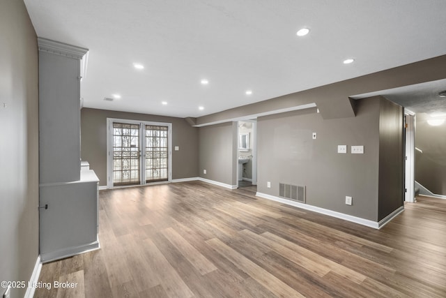 unfurnished room featuring visible vents, recessed lighting, light wood-type flooring, and baseboards