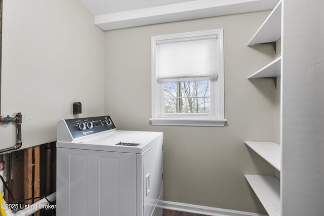 clothes washing area with baseboards, washer / clothes dryer, and laundry area