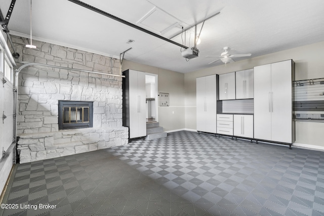 garage with baseboards, a garage door opener, and a ceiling fan