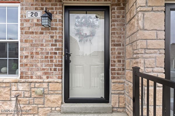 doorway to property featuring brick siding