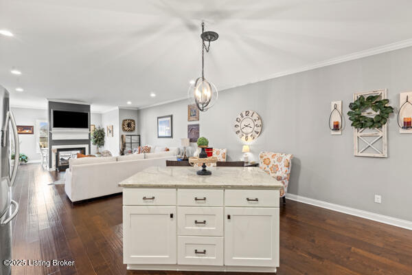 kitchen featuring dark wood finished floors, a fireplace, white cabinets, light stone countertops, and baseboards