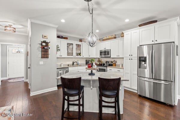 kitchen featuring dark wood finished floors, light countertops, appliances with stainless steel finishes, white cabinetry, and a kitchen island