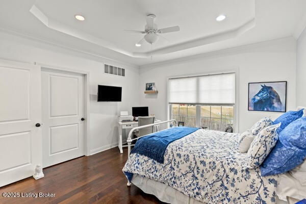 bedroom with recessed lighting, wood finished floors, visible vents, baseboards, and a tray ceiling