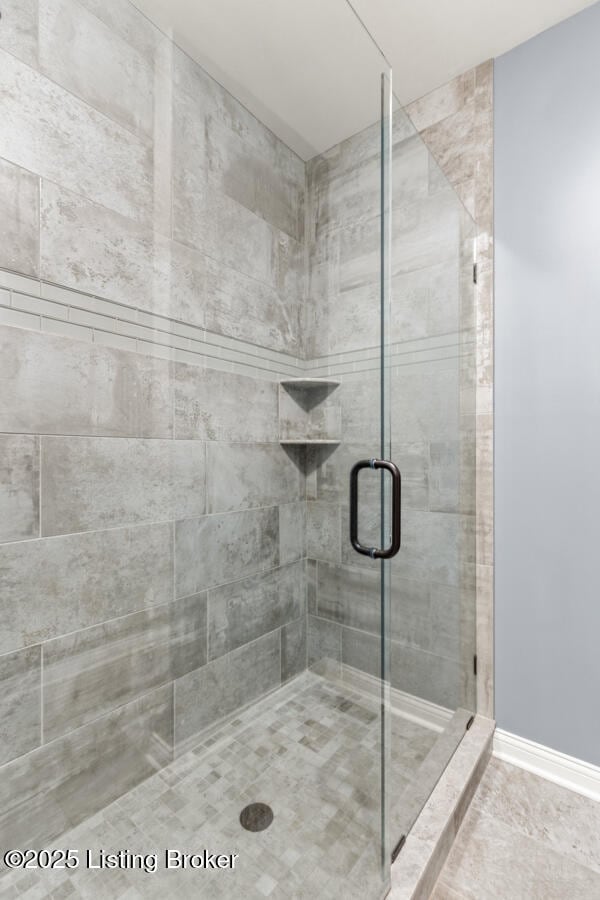 bathroom with a stall shower and baseboards