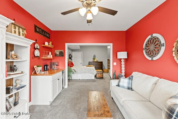 carpeted living area with a ceiling fan