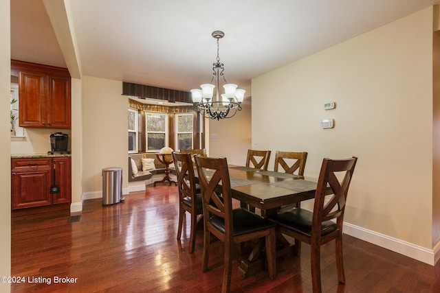 dining space with dark wood-style flooring, an inviting chandelier, and baseboards