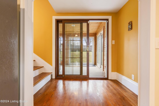 doorway to outside featuring hardwood / wood-style flooring, stairs, and baseboards