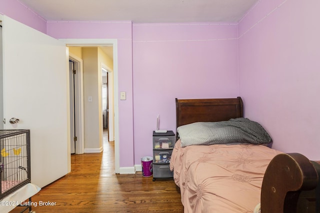 bedroom featuring baseboards and wood finished floors