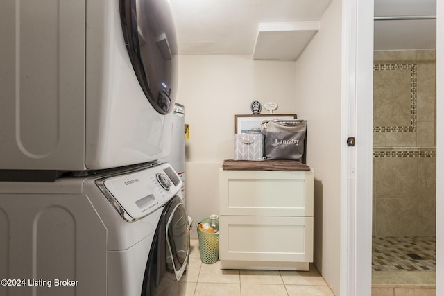 clothes washing area featuring stacked washer and dryer, laundry area, and light tile patterned floors