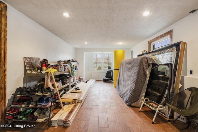 interior space featuring a textured ceiling, wood finished floors, visible vents, and recessed lighting