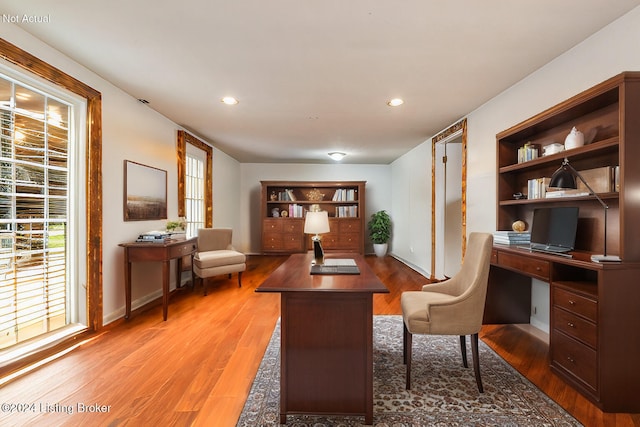 office space featuring built in shelves, recessed lighting, wood finished floors, and baseboards