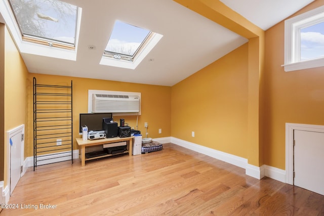 office with lofted ceiling with skylight, baseboards, wood finished floors, and a wall mounted air conditioner