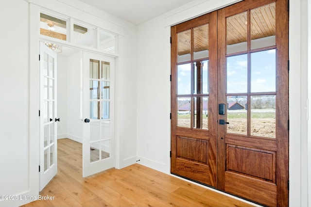 entrance foyer featuring french doors, baseboards, and light wood-style floors