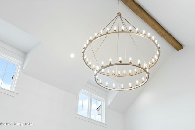 room details with beamed ceiling and an inviting chandelier