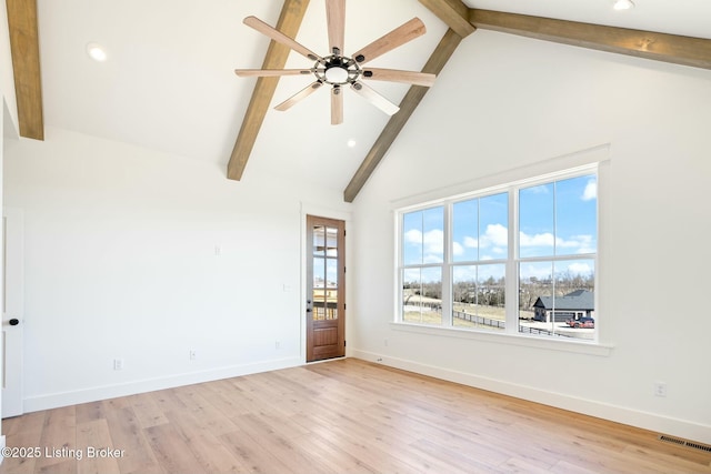 unfurnished room with baseboards, visible vents, high vaulted ceiling, beam ceiling, and light wood-type flooring