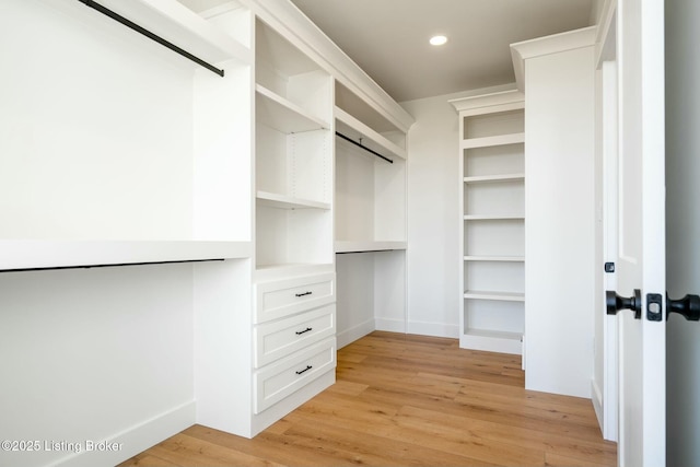 spacious closet featuring light wood-style flooring and built in study area