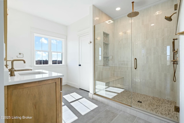 bathroom with baseboards, a stall shower, and vanity