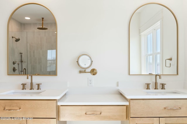 full bathroom featuring a sink, two vanities, and a shower stall