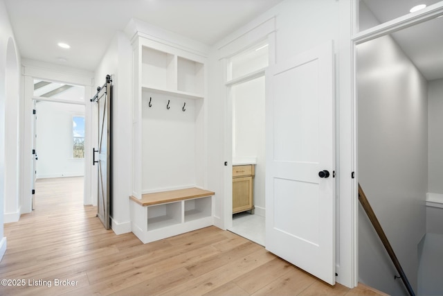 mudroom featuring recessed lighting, light wood-style flooring, and a barn door