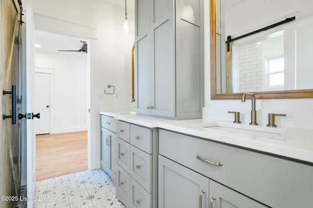 bathroom with double vanity, baseboards, and a sink