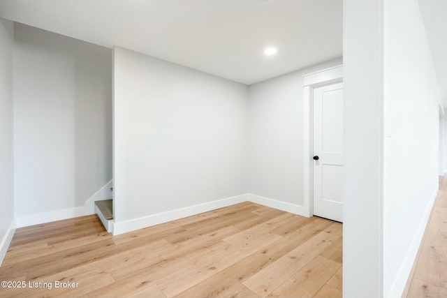 empty room featuring recessed lighting, baseboards, and light wood-style floors