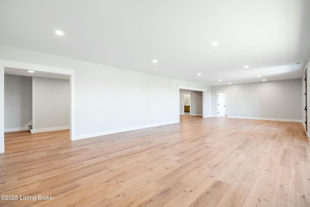 unfurnished living room with light wood-style flooring, recessed lighting, and baseboards