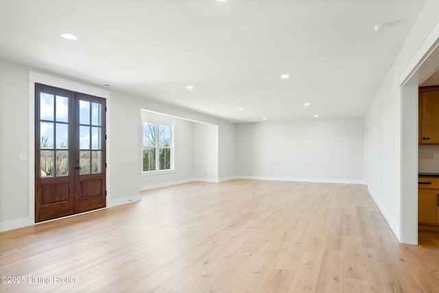 unfurnished living room with light wood-type flooring, french doors, baseboards, and recessed lighting