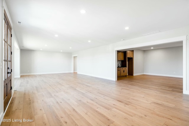 spare room with recessed lighting, light wood-type flooring, and baseboards