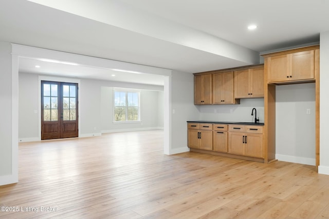 kitchen featuring baseboards, dark countertops, and light wood finished floors