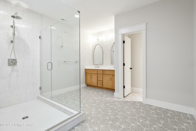 full bath with a shower stall, vanity, and baseboards