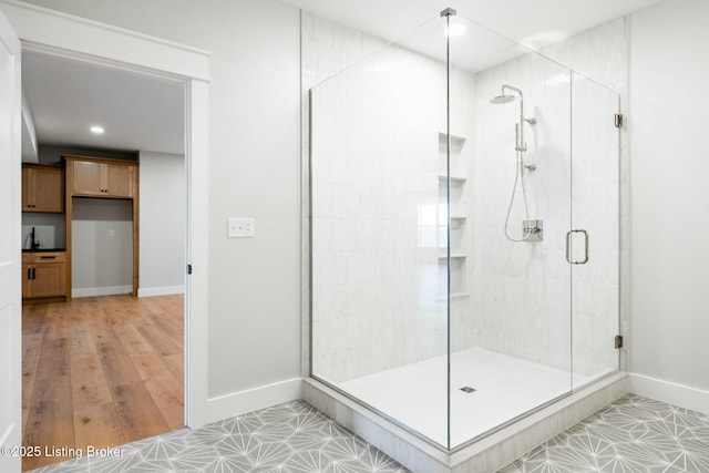 full bath featuring a stall shower and baseboards