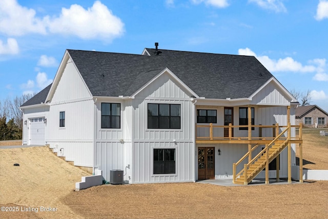 rear view of house featuring board and batten siding, a shingled roof, cooling unit, french doors, and an attached garage