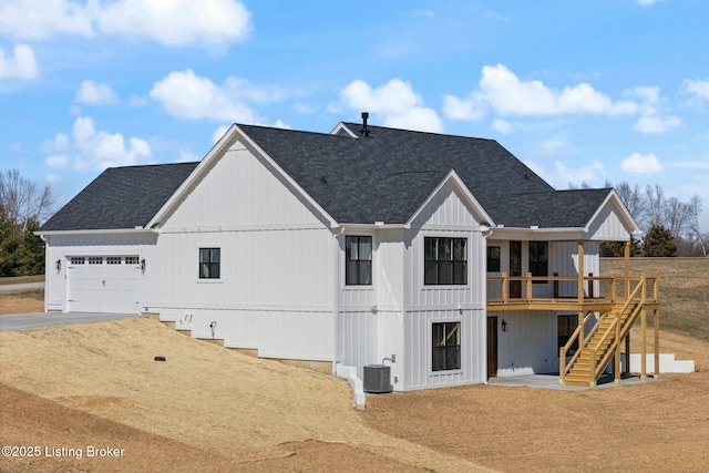 exterior space with board and batten siding, stairs, roof with shingles, central AC unit, and a garage