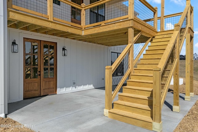 property entrance featuring board and batten siding and french doors